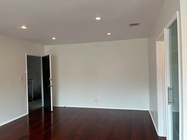 Living room area leading to unit entrance and bedroom hallway