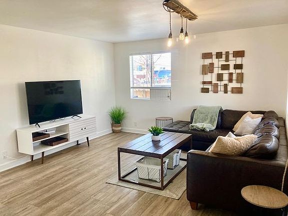 Large living space with streaming TV, boho style furnishings and cozy accents.