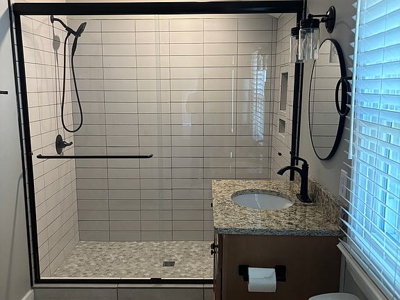 New bathroom with 5' tile shower, custom cabinet, granite countertop and tile floor.
