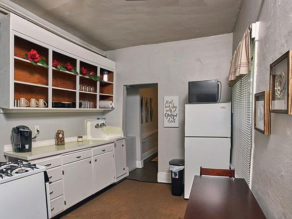 Full kitchen stocked with utensils, dishes, kettles, baking items.