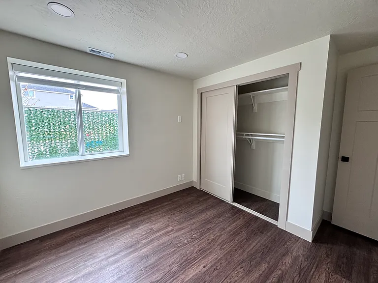 Bedroom with abundant natural light and a spacious closet.