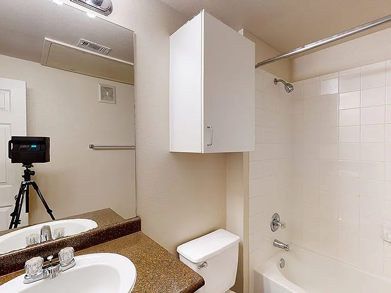 Apartment bathroom with large soaking tub and wood-style flooring.
