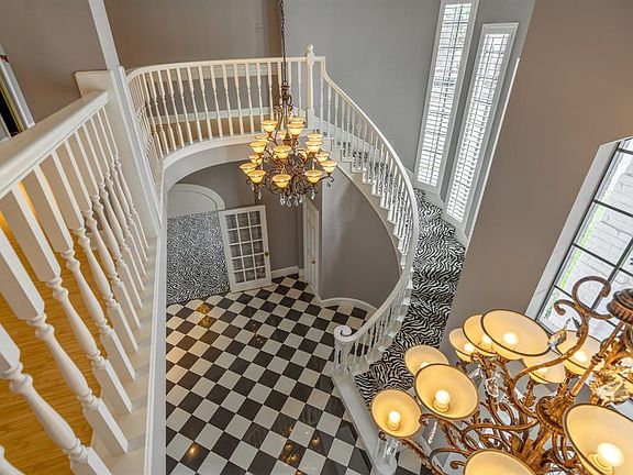 A view from the upstairs landing, showcasing the spiral staircase and the family of chandeliers.