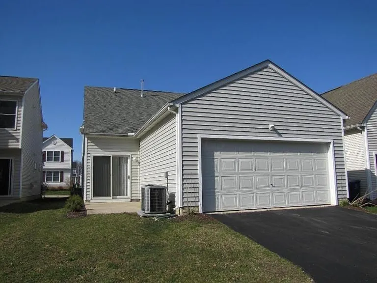 Rear view of the house with 2-car Garage & a patio.