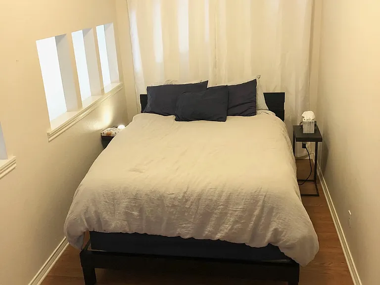 The bedroom is small, but has room for a small couch, desk or table and chairs where the photographer is standing