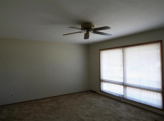 Living Room 17x13 features two large windows, freshly painted, hardwood floors under carpeting.