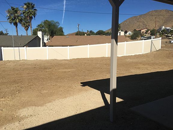 fenced in back yard with patio and cover