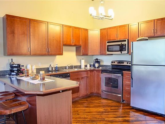 The open plan kitchen has stainless appliances, upgraded cabinetry and a breakfast bar.