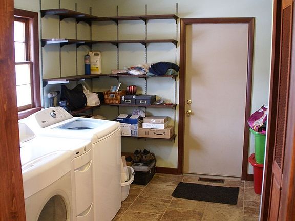 Porcelain tile, floor-to-ceiling shelving, and door to backyard