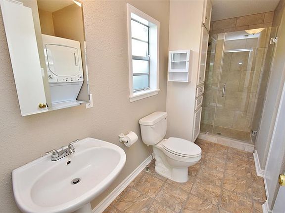 Bathroom with glass door shower and washer/dryer.