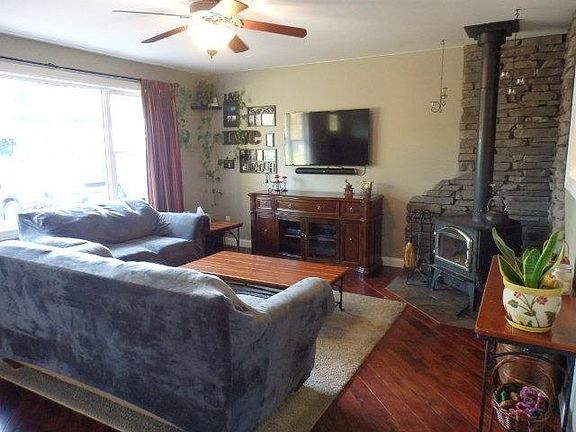 Beautiful living room with wood burning fireplace, hardwood flooring, large picture window.