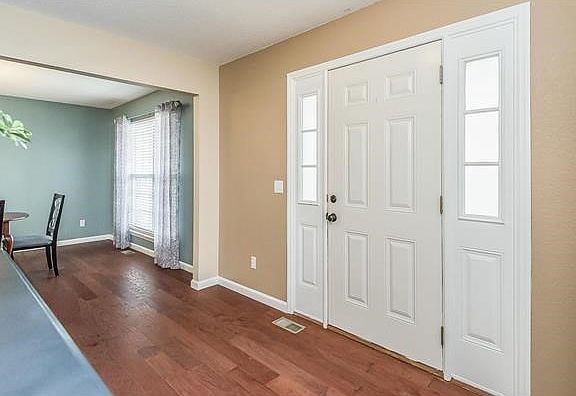 View of the Entry from the Living Room looking into the Dinning Room. Hardwood floors are throughout the Entry, Living Room, Dinning Room, Powder Room, and Family Room.