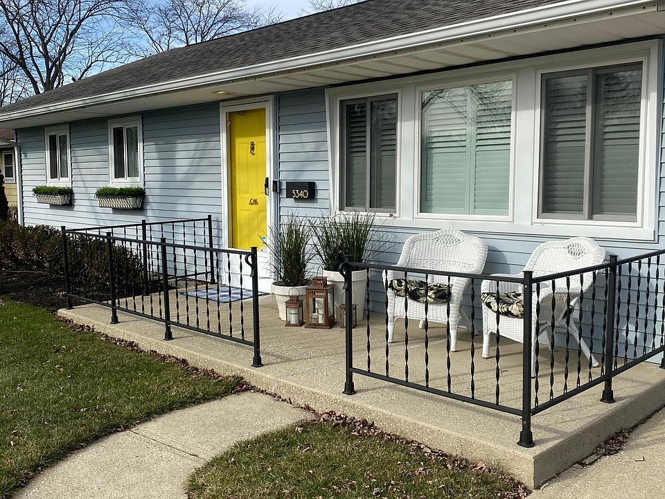 Welcoming wrought iron window boxes, cheery front door and porch featuring original (refurbished) wrought iron railing.