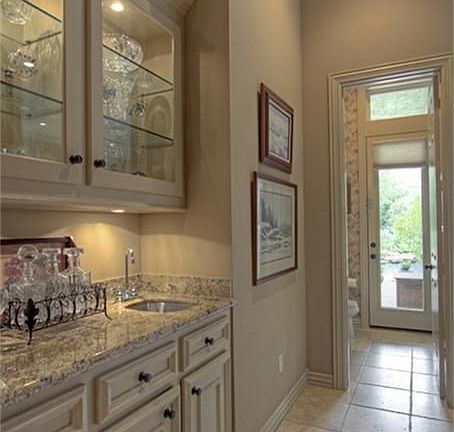 Hallway to kitchen features a butler's pantry w/sink and accent lighting.