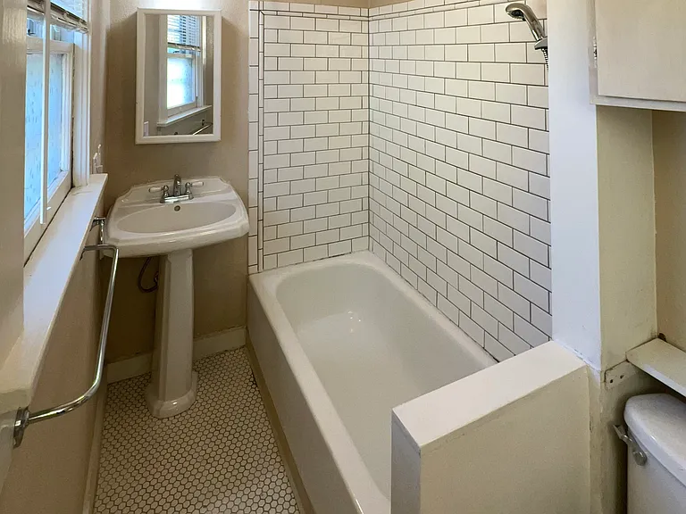 Tiled bathroom with shower and full bathtub.