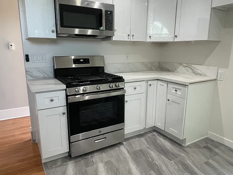 Range and kitchen cabinets on East wall of Kitchen.