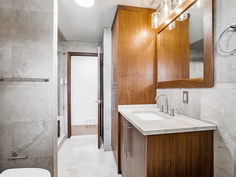 Hallway bathroom- full shower, stand alone bath tub and stunning walnut cabinets.