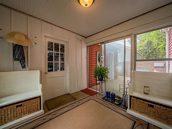 BREEZEWAY WITH DOORS LEADING TO QUAINT BACKYARD