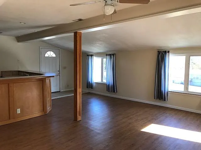 dining/living area open to kitchen; windows on two walls