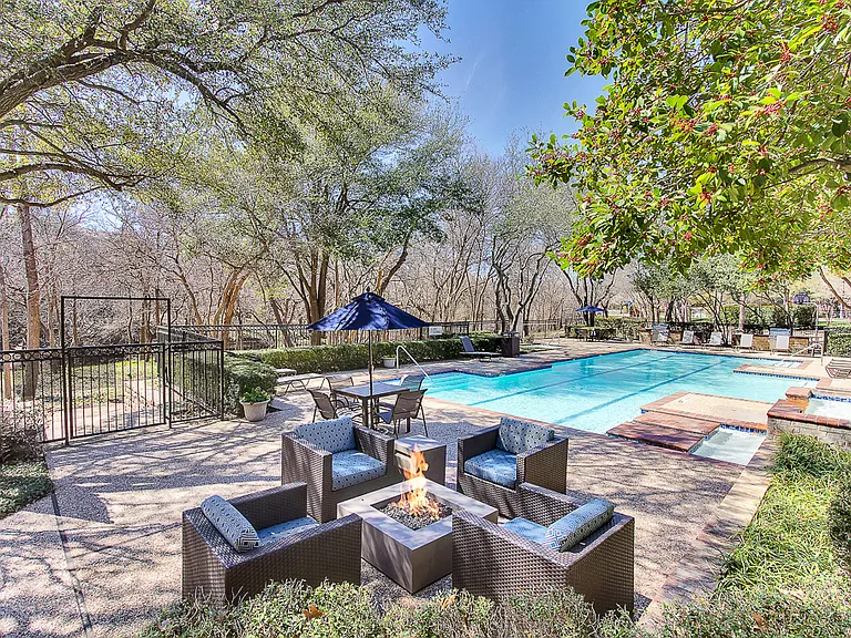 Stunning, tree-lined swimming pool and hot tub with fire pit, tanning deck and lounge seating