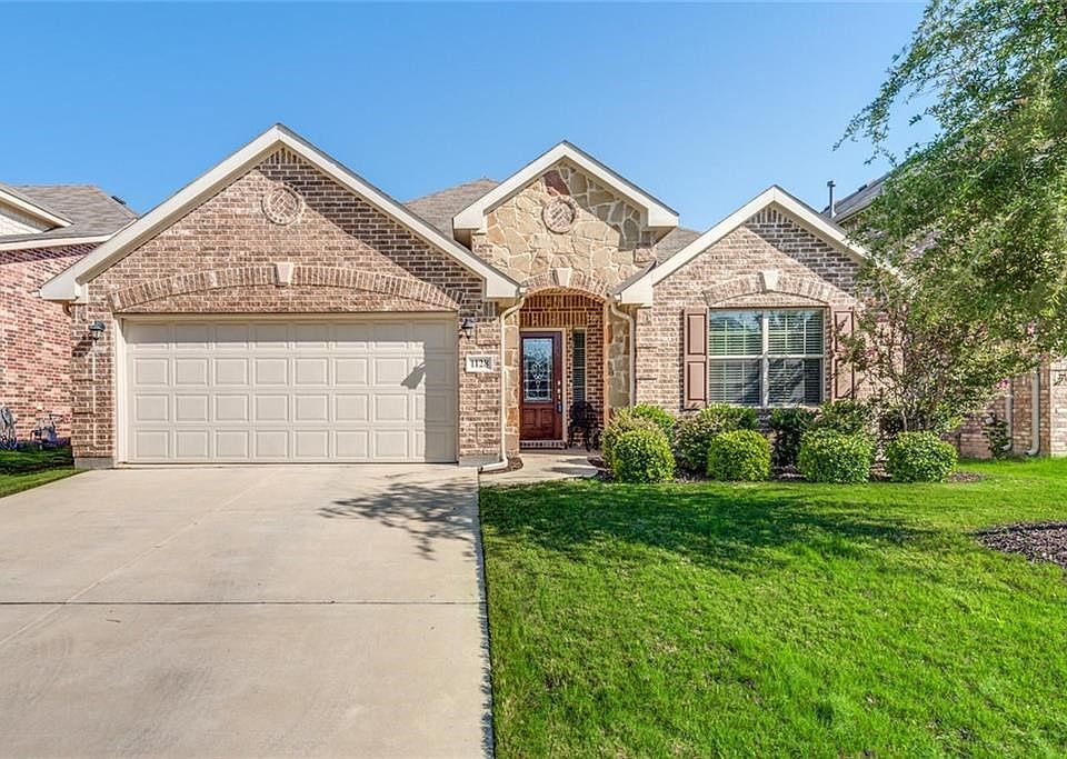 One story 3 bedroom plus study has brick and stone elevation with gutters and 2 car garage.