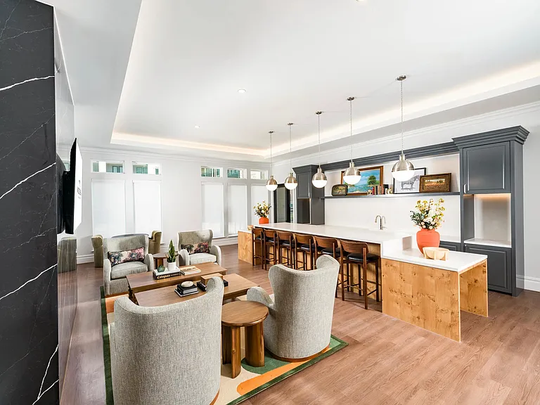 Community gathering space with a long bar, pendant lighting, and open seating arranged for hosting, conversation, and shared moments.