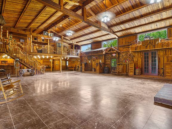 Wooden walls, high vaulted ceiling, a wood ceiling with exposed beams, and stairs