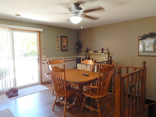 Sunny eating area painted a calming green. Enjoy your meal and go onto the deck to relax!
