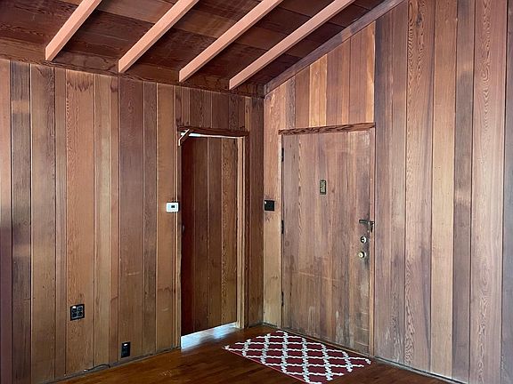 Great room with oak flooring, old growth redwood paneling and open beam ceiling.