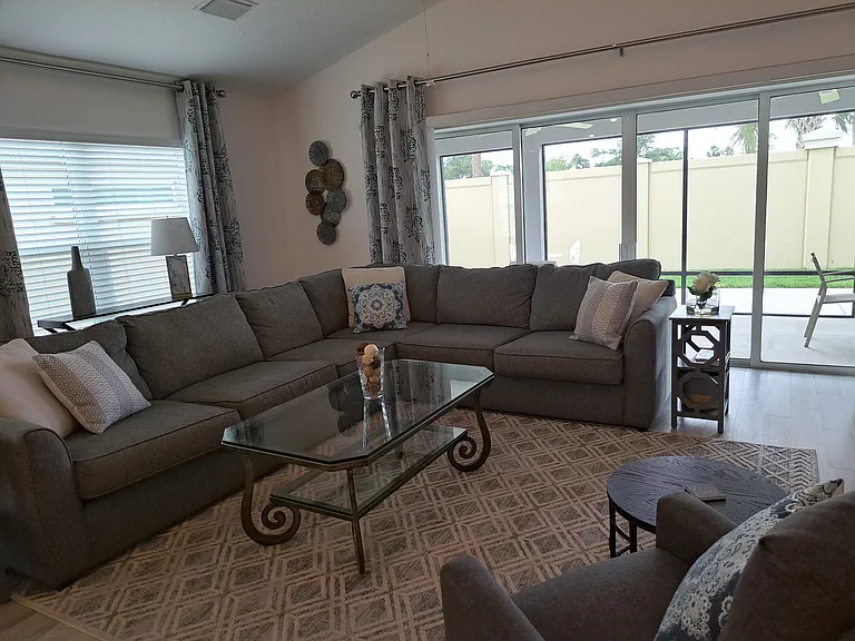 Living room adjacent to lanai and fenced in backyard for privacy.