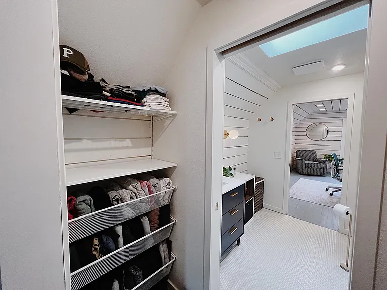 Primary bedroom closet looking into bathroom
