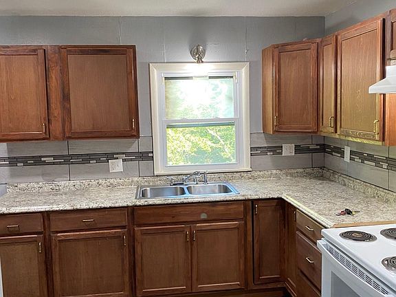 Kitchen with band new cabinet , stove , wood floor , beautiful lighting !