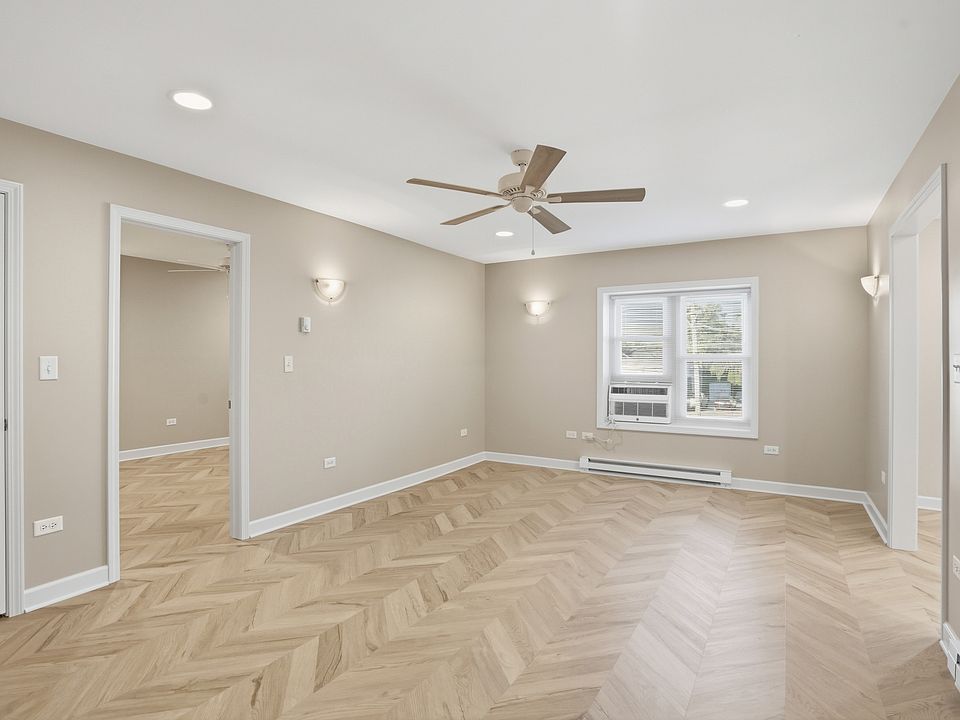 Spacious living room with ceiling fan between kitchen and bedroom.