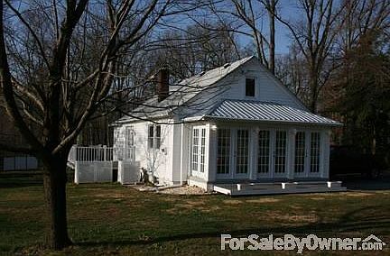 FRONT OF HOUSE WITH ENCLOSED PORCH
						:
						New metal roof enhances the 5 double french doors.