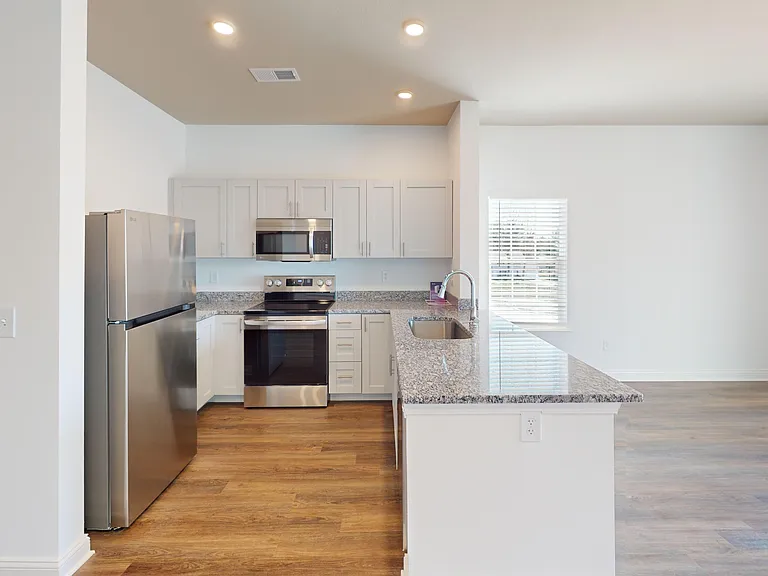 The Roth is an open-concept floor plan with a kitchen featuring a breakfast bar, granite countertops, and stainless steel appliances. The Roth is an open-concept floor plan with a kitchen featuring a breakfast bar, granite countertops, and stainless steel