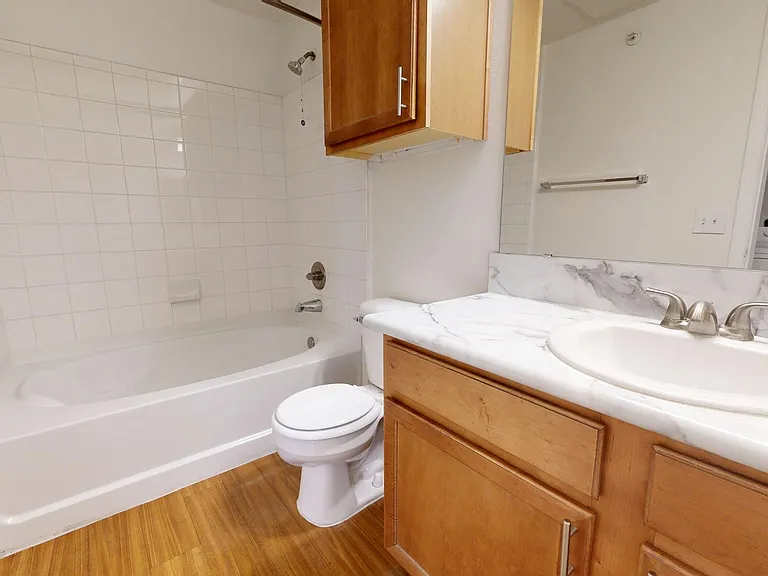 Apartment Bathroom with large soaking tub and Wood Style Flooring.
