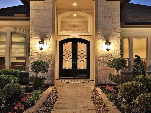 STUNNING LANDSCAPE LINES THE STAMPED CONCRETE PATTERNED WALKWAY - Staggering entrance offers a lovely setting with stone pathway articulating the image of quality with architectural purity imparting stellar curb appeal. Arched windows, lush greenery 