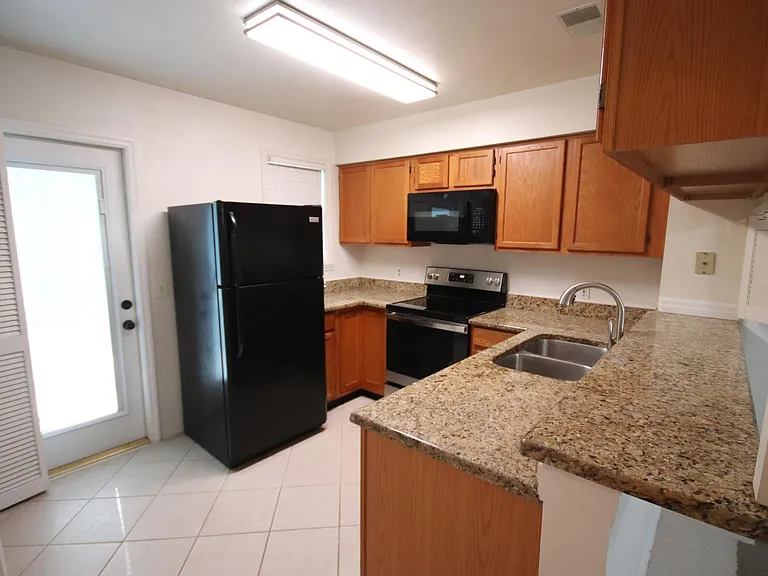 Fridge with ice maker. Rear door to fenced private patio.