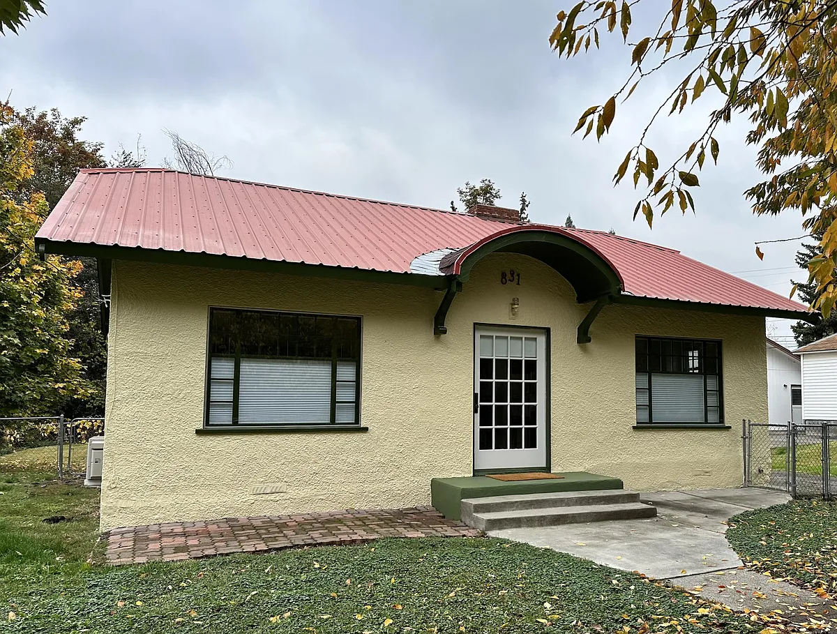 Valencia Cottage's exterior showcases its 1926 charm: a curved entry, large original windows with divided lites, and a giant original front door. - 831 Valencia St