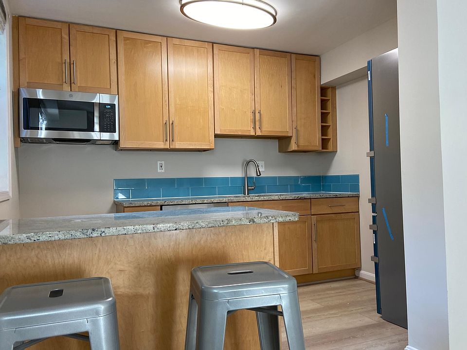 Open concept kitchen with new stainless steel refrigerator microwave and range