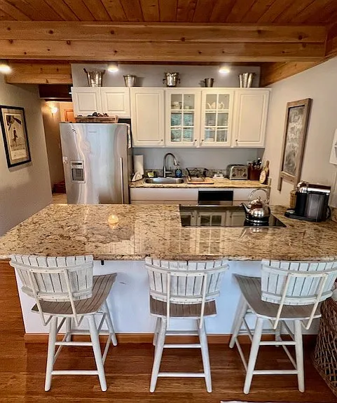 Breakfast bar, fully stocked kitchen, stainless appliances including small dishwasher.