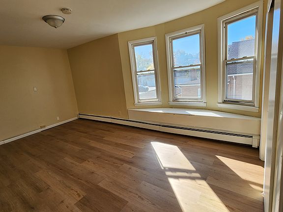 Large bedroom with bay window and seat also has a full closet. New wood flooring.