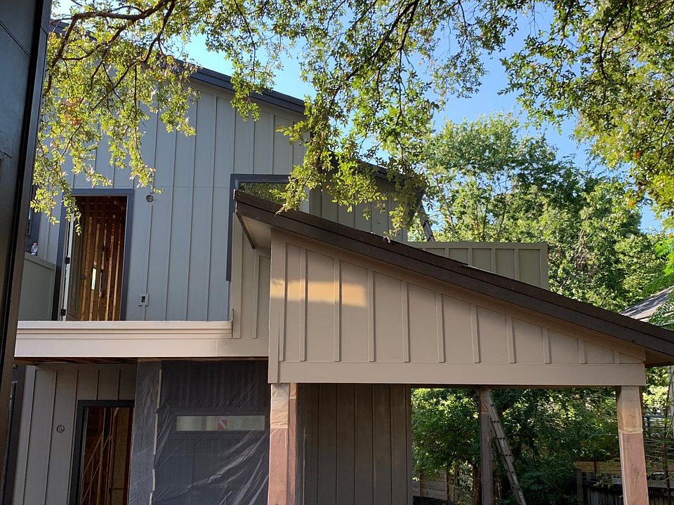 Taken from private driveway looking onto front of house with carport and master suite balcony.