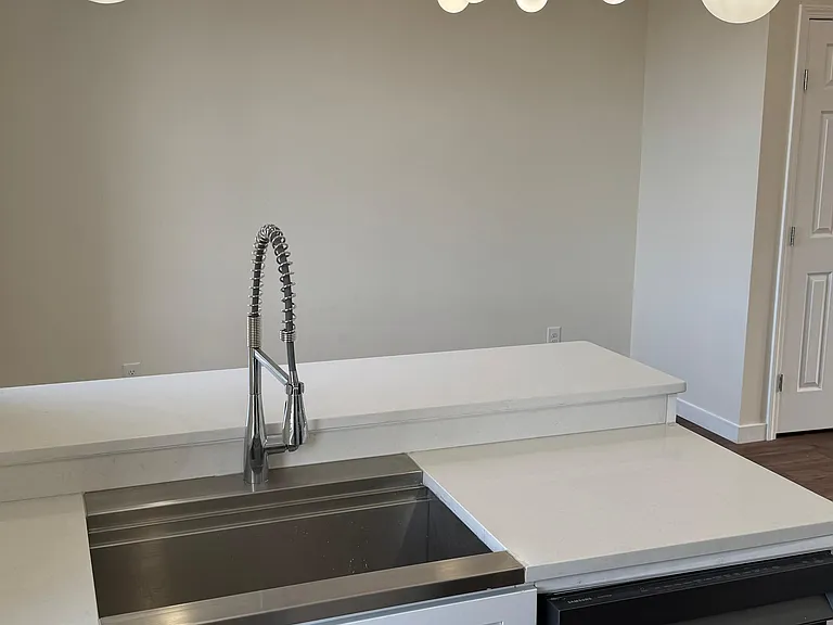 Modern kitchen featuring granite countertops, stainless steel appliances, updated cabinetry, and stylish lighting designed for both comfort and functionality.