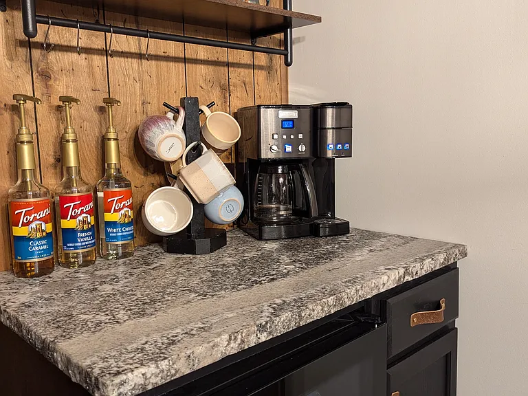 Coffee Bar complete with Coffee Maker for Full-Size Coffee Pot with Ground Coffee or Single-Serve K-Cups. Starter Torani Coffee Syrup and K-Cups provided! Mini Fridge - extra fridge space to store any drinks you like!