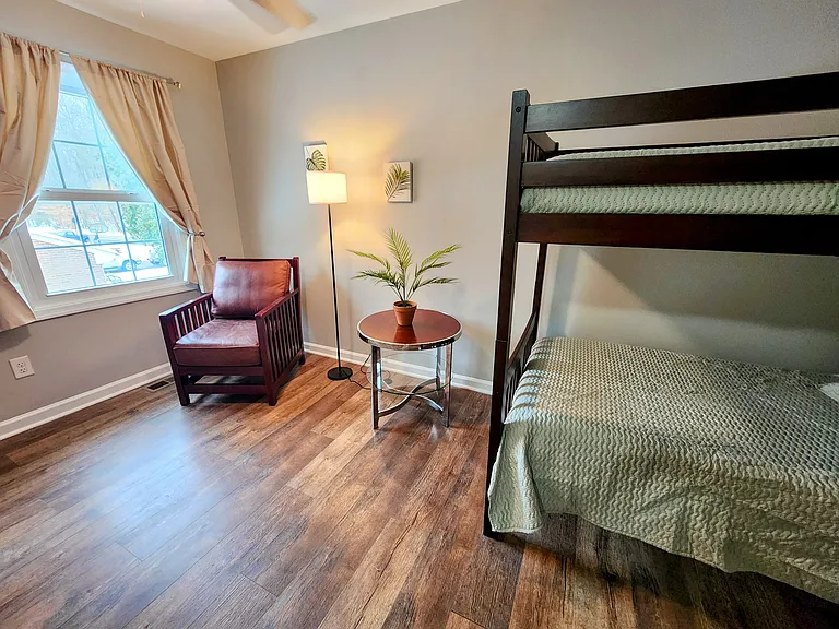 Upstairs bedroom with a bunk bed, blackout curtains, and full en-suite bathroom. The bunk bed can be converted into two twin beds upon request.
