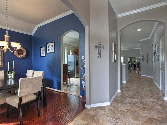Arched door openings accent the entrance to the formal dining room, kitchen, and living areas.