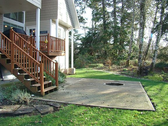 Steps from the deck lead to the concrete patio surrounding a firepit.