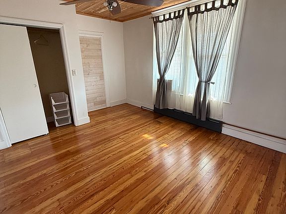 larger bedroom with closet and street facing windows