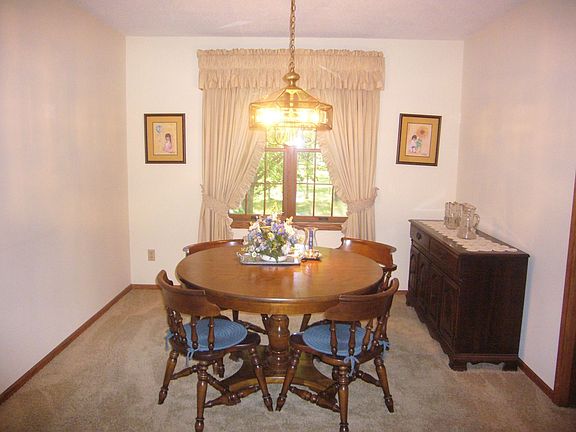 The formal dining area has a chandelier and a window overlooking the backyard.